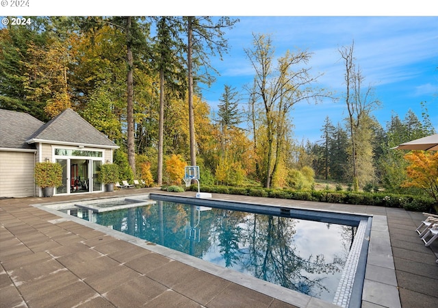 view of pool featuring a patio area and an in ground hot tub