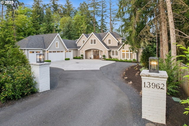 view of front of home featuring a garage, fence, and driveway