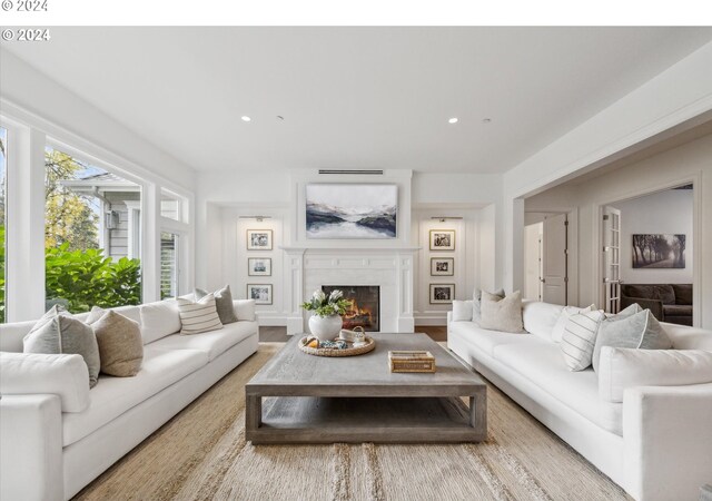 living area featuring recessed lighting and a warm lit fireplace