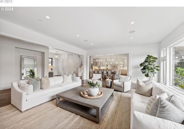 living room with light hardwood / wood-style floors and an inviting chandelier