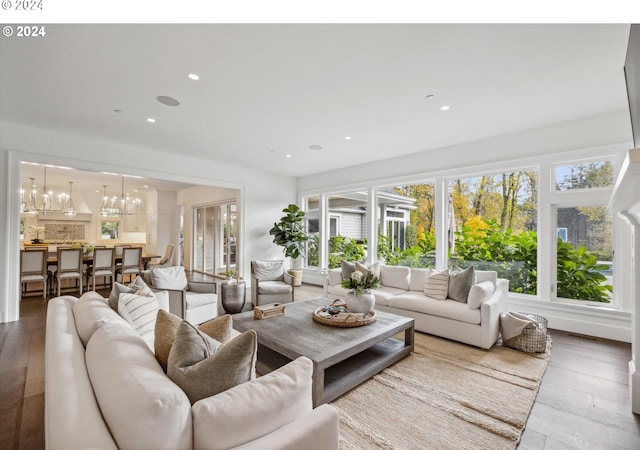 living room with a chandelier, recessed lighting, and wood-type flooring