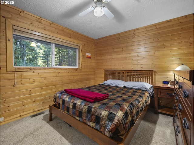 bedroom featuring carpet floors, wood walls, and ceiling fan