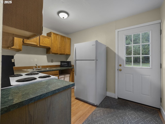 20480 E Lolo Pass Rd, Rhododendron, OR 97049 - kitchen with freestanding refrigerator, dark countertops, white range with electric stovetop, a sink, and light wood-style flooring