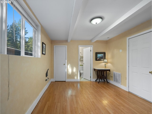 foyer featuring wood-type flooring and beamed ceiling