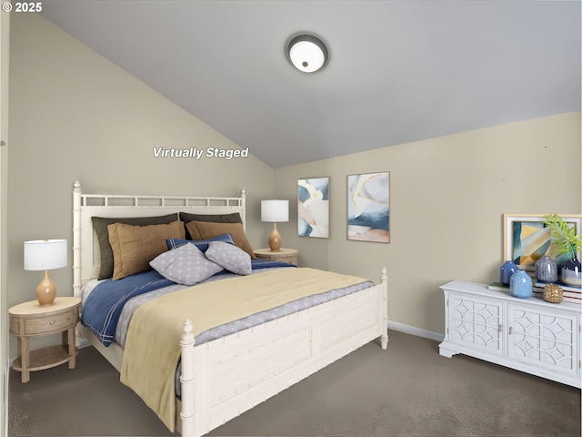 bedroom featuring lofted ceiling and dark carpet