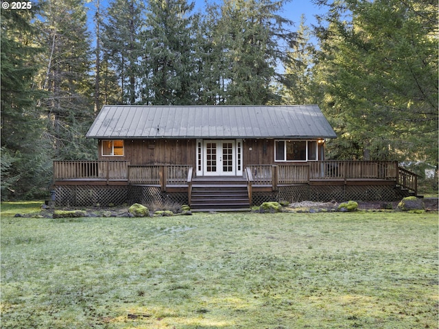 view of front of property with a deck and a front lawn