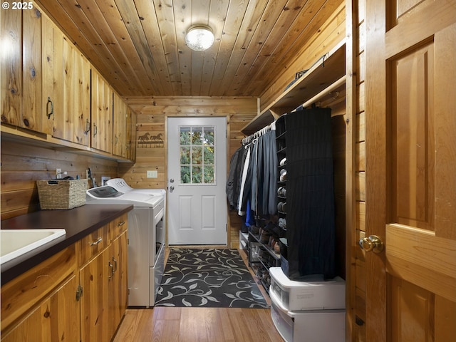 laundry area featuring wooden ceiling, cabinets, separate washer and dryer, wood-type flooring, and wood walls