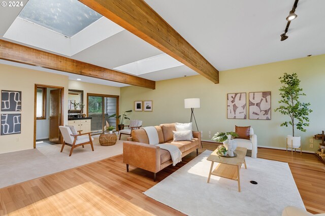 living room with beam ceiling, light wood-type flooring, and track lighting