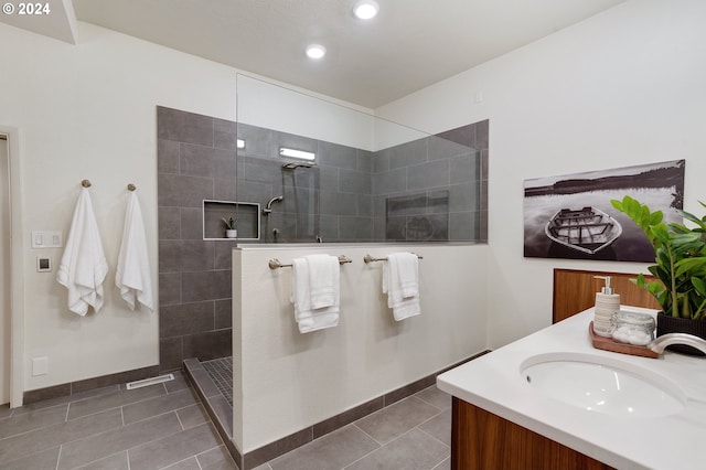 bathroom featuring tiled shower, tile patterned flooring, and vanity