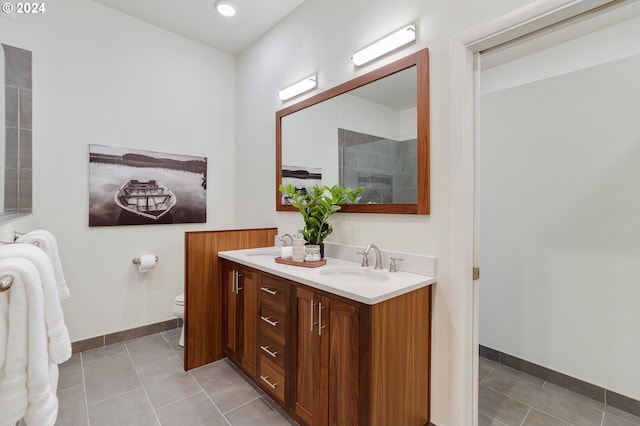 bathroom featuring toilet, tile patterned flooring, and double vanity