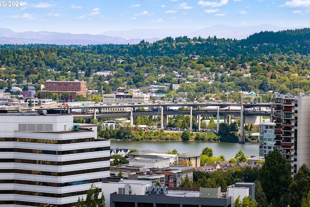 property's view of city with a water and mountain view