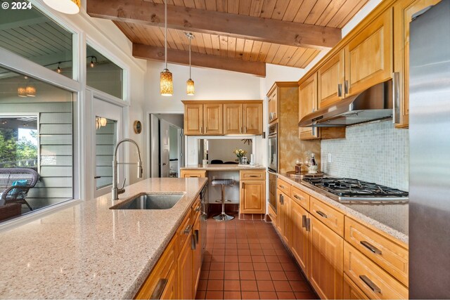 kitchen featuring pendant lighting, sink, appliances with stainless steel finishes, lofted ceiling with beams, and light stone countertops