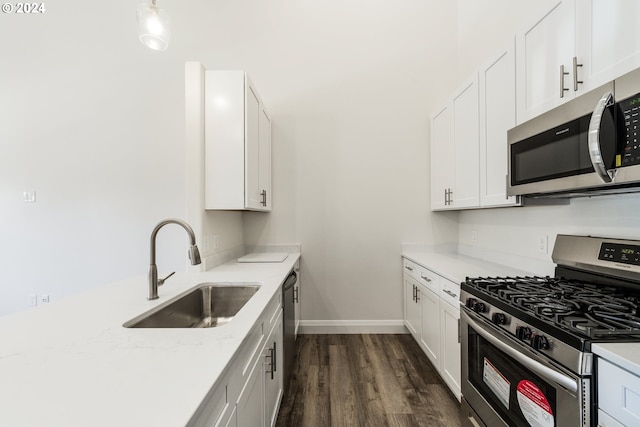 kitchen featuring white cabinets, sink, dark hardwood / wood-style floors, light stone countertops, and appliances with stainless steel finishes