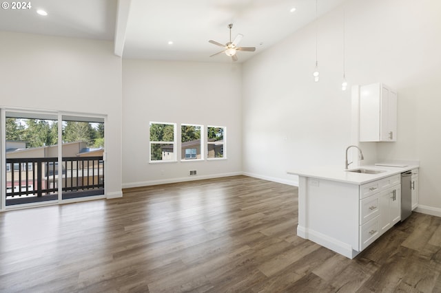 unfurnished living room with plenty of natural light, sink, high vaulted ceiling, and dark wood-type flooring