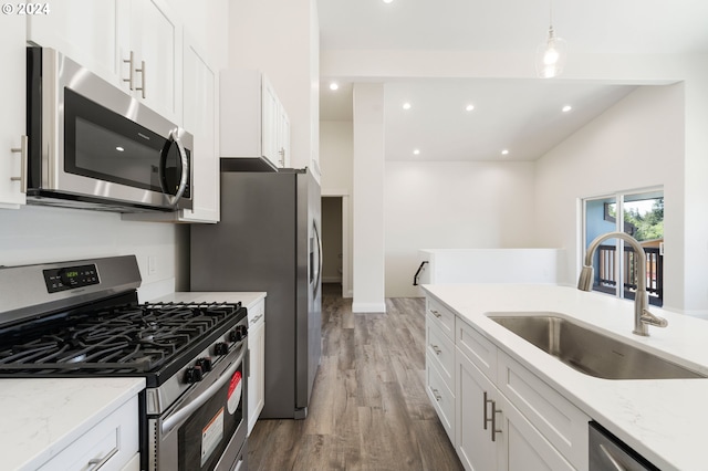 kitchen featuring appliances with stainless steel finishes, white cabinetry, light hardwood / wood-style flooring, and sink