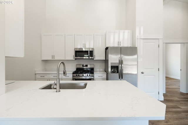 kitchen featuring light stone counters, sink, white cabinets, and appliances with stainless steel finishes