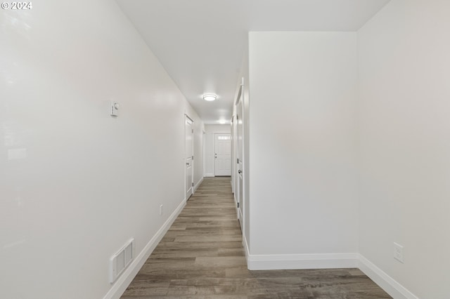 corridor with hardwood / wood-style flooring