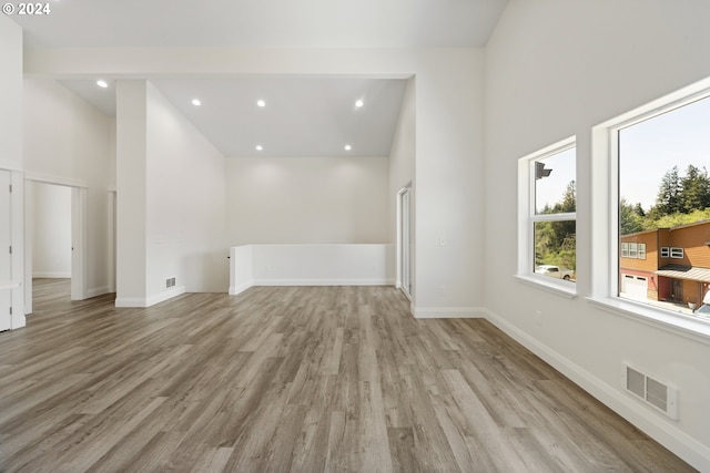 interior space with light hardwood / wood-style flooring and high vaulted ceiling