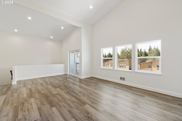 unfurnished living room featuring light wood-type flooring and high vaulted ceiling