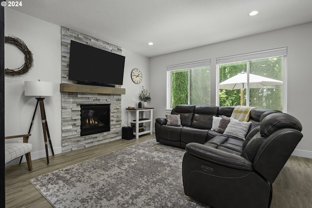 living room with hardwood / wood-style flooring, a fireplace, and a textured ceiling