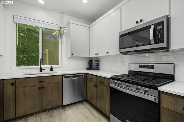 kitchen featuring plenty of natural light, white cabinets, stainless steel appliances, and sink