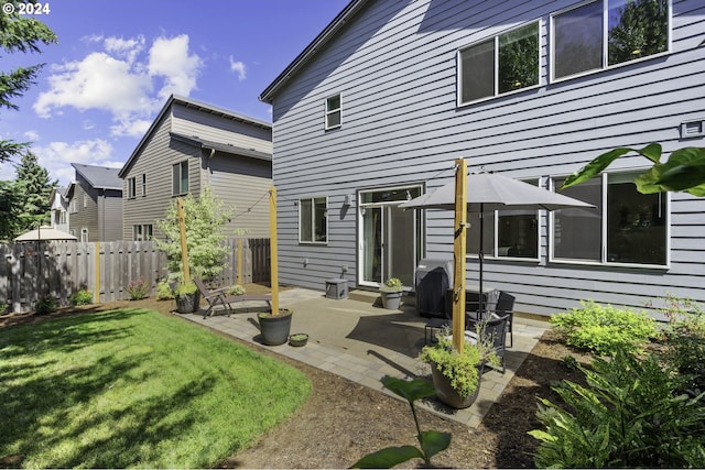 back of property with a lawn and a patio area