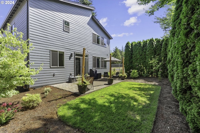 back of house with a patio area and a yard