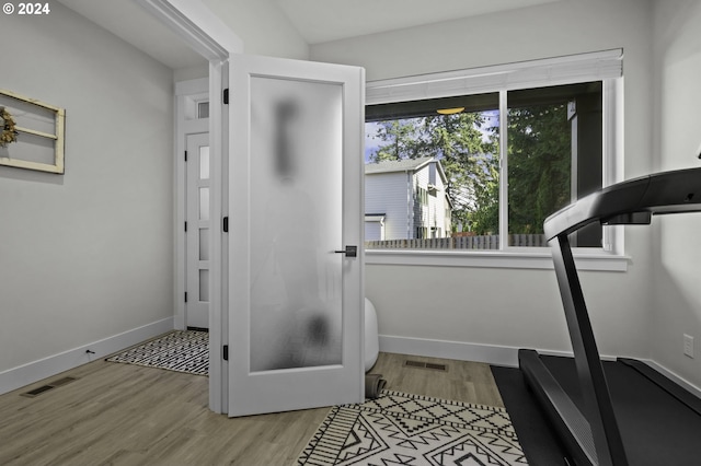 workout room with light hardwood / wood-style flooring