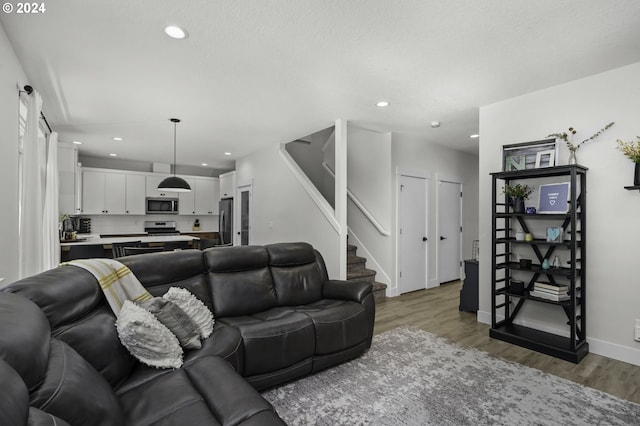 living room with a textured ceiling and light hardwood / wood-style flooring