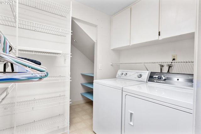 washroom featuring washing machine and clothes dryer and cabinets