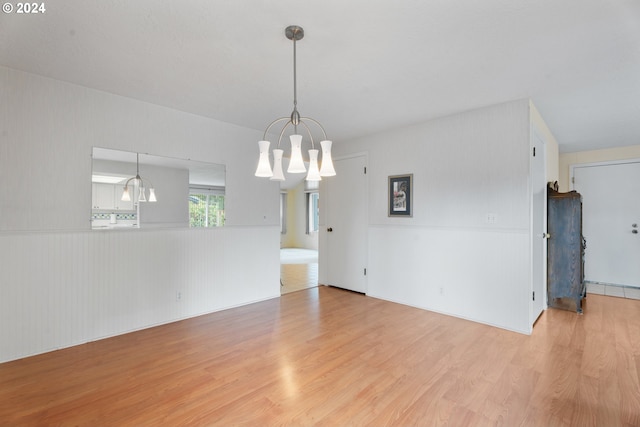 spare room featuring a chandelier and hardwood / wood-style flooring