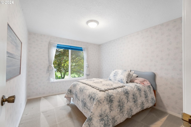 bedroom with light carpet and a textured ceiling