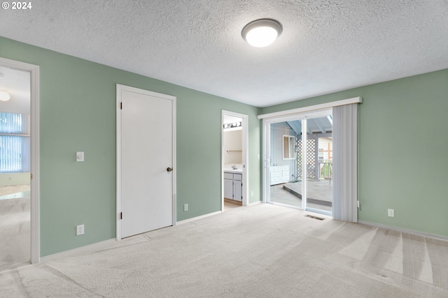 empty room with light carpet and a textured ceiling