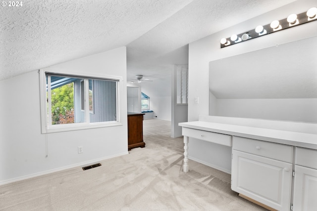 interior space with a textured ceiling, ceiling fan, and lofted ceiling