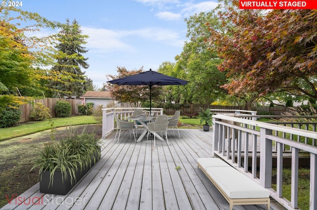 wooden terrace featuring a yard