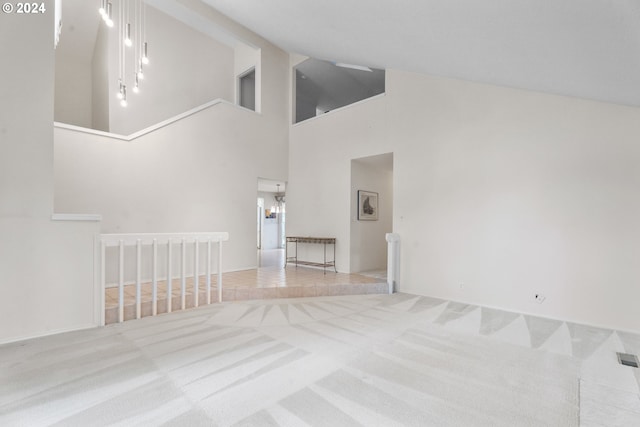 unfurnished living room with light colored carpet and a high ceiling