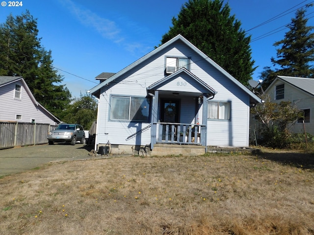 bungalow-style house featuring covered porch and a front yard