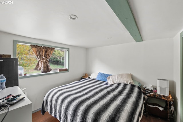 bedroom with beam ceiling and hardwood / wood-style flooring