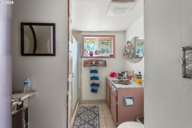 bathroom featuring vanity, a shower with shower door, and tile patterned flooring