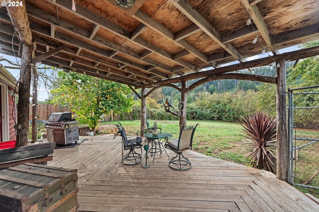 wooden deck with area for grilling and a yard