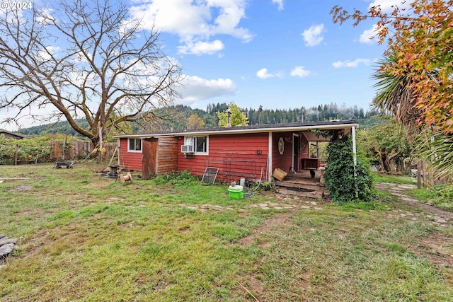 back of property featuring a lawn and fence