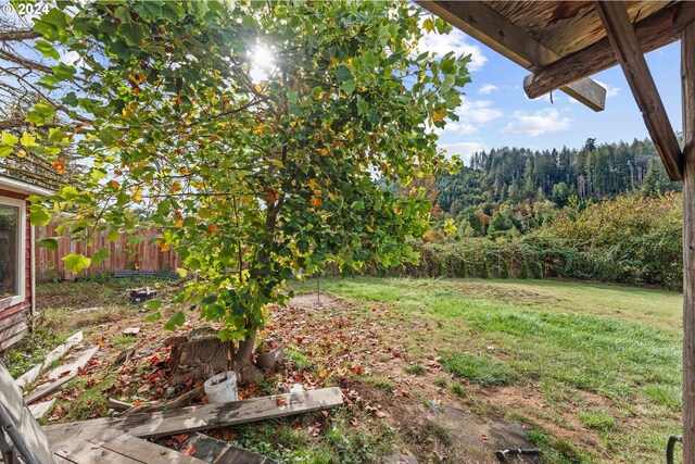 view of yard with fence and a wooded view
