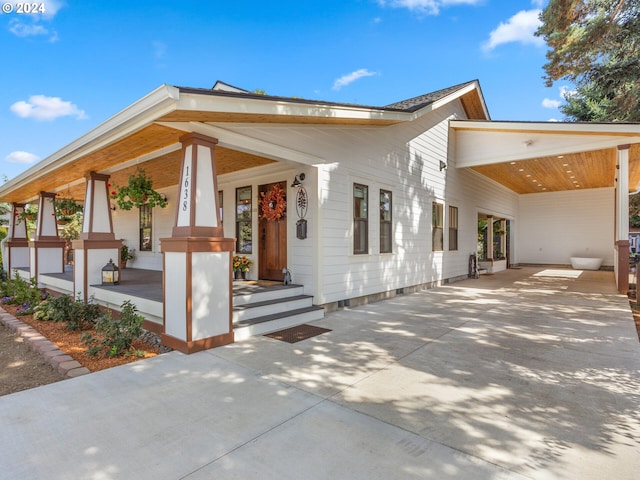 view of front facade featuring a carport, covered porch, and driveway