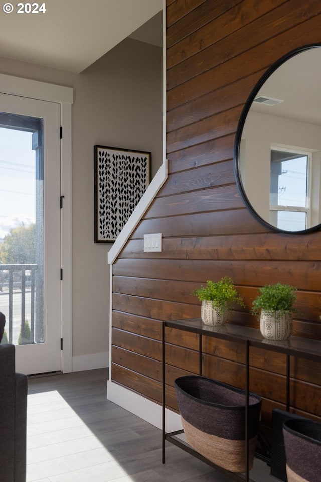 interior space with hardwood / wood-style floors and wood walls