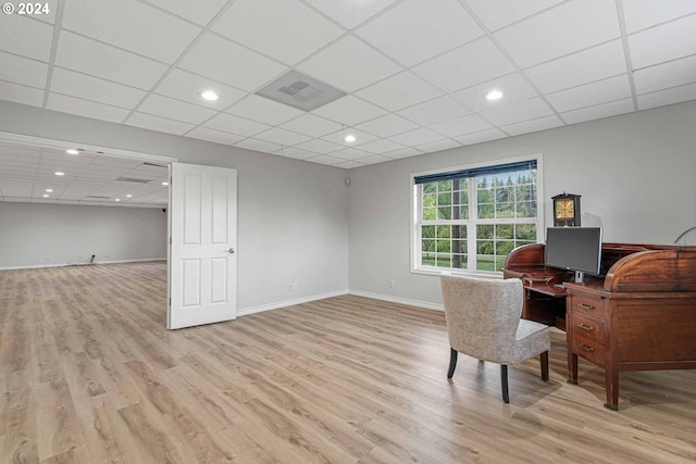 office area with light wood-type flooring and a paneled ceiling