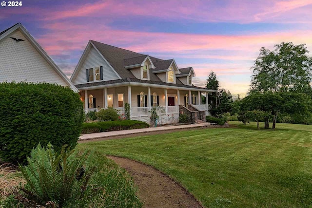 view of front of property with a porch and a lawn