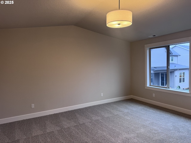 spare room featuring carpet and lofted ceiling