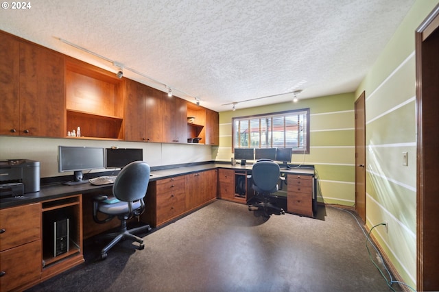 office with built in desk and a textured ceiling