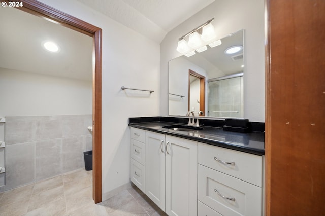 bathroom with vanity, a shower with shower door, and tile patterned flooring