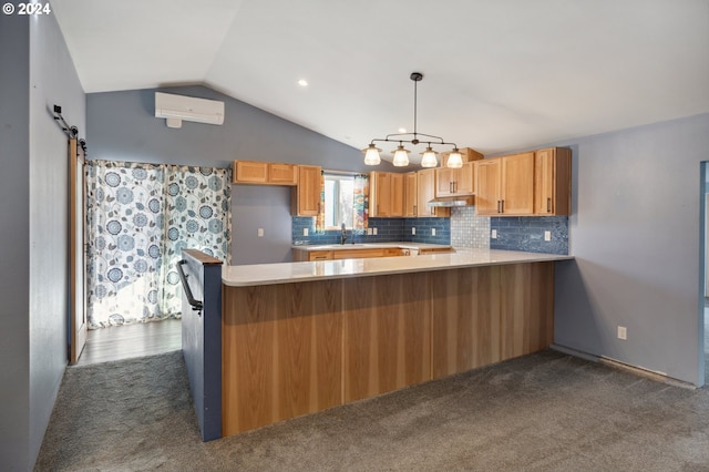 kitchen with a wall unit AC, kitchen peninsula, a barn door, dark carpet, and pendant lighting